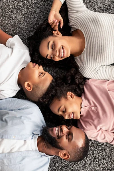 Porträtt av svart familj liggande på golvet tillsammans — Stockfoto