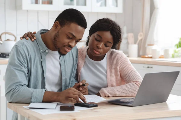 Porträt eines jungen afrikanischen Paares, das in der Küche am Tisch sitzt und Dokumente liest — Stockfoto