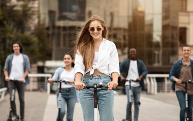 Arkadaşlarıyla motosiklete binen bir kadın.