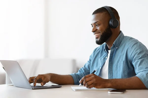 Online oktatás. Happy Black Guy Tanulmány az interneten, Webinar megtekintése a laptopon — Stock Fotó