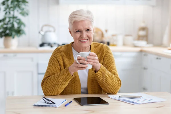 Glückliche ältere Frau bei Kaffeepause während des Online-Studiums — Stockfoto