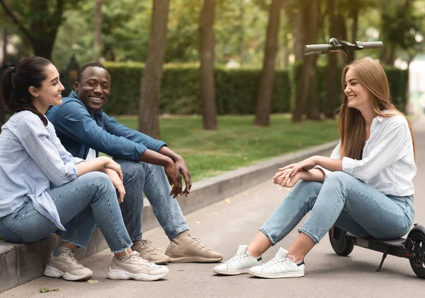 Três amigos diversos gastando tempo no parque e conversando — Fotografia de Stock