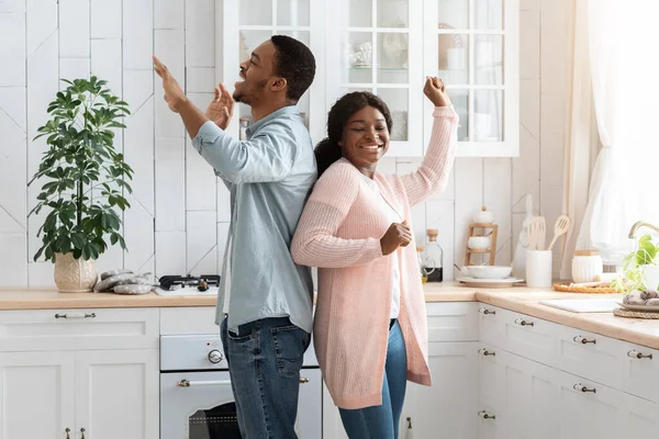 Amusant domestique. Portrait de couple afro-américain énergique dansant à l'intérieur de la cuisine — Photo