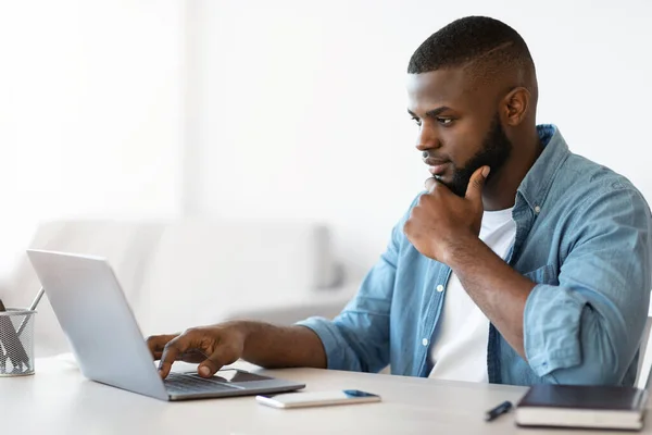 Práce na dálku. Millennial Black Freelancer Guy pracuje s počítačem na domácí kanceláři — Stock fotografie