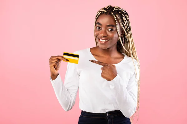 Mulher negra segurando cartão de crédito e apontando para ele — Fotografia de Stock