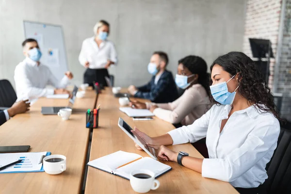 Bizneswoman In Face Mask Korzystanie z tabletu podczas spotkania korporacyjnego Kryty — Zdjęcie stockowe