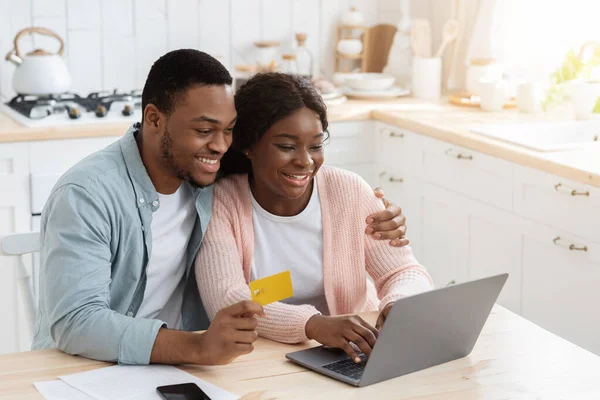 Αφρικανική οικογένεια πληρώνουν λογαριασμούς χρησιμότητας στο σπίτι με το lap-top και την πιστωτική κάρτα — Φωτογραφία Αρχείου