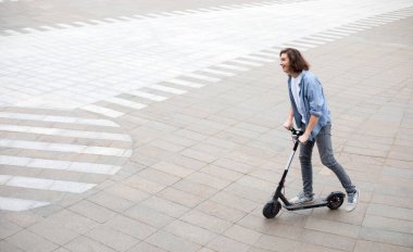 Heyecanlı adam elektrikli scooter 'a biniyor.