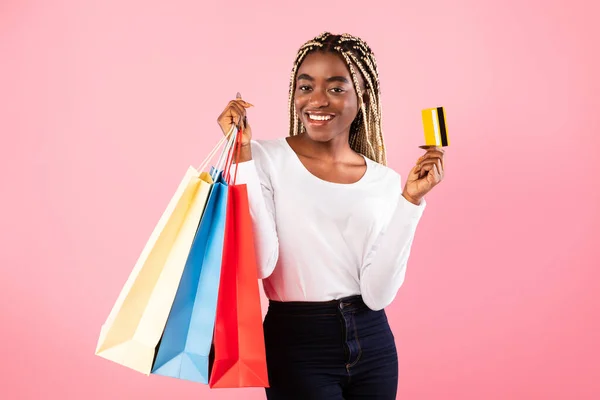 プラスチッククレジットカードとショッピングバッグを保持黒の女性 — ストック写真