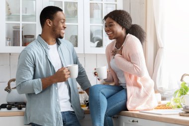 Neşeli siyah aşıklar mutfakta kahve içerken eğleniyorlar.