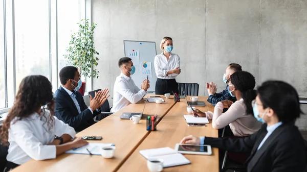 Empresarios aplauden aprobación de una exitosa presentación en el cargo durante la reunión — Foto de Stock