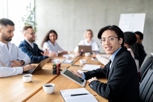 Asian Businessman Using Digital Tablet Attending Corporate Meeting In Office