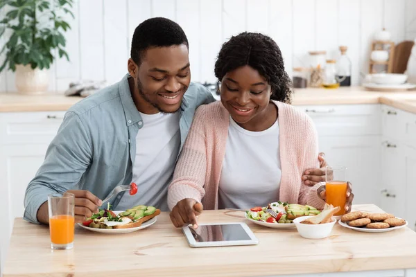 Νέοι μαύροι Millennial σύζυγοι ψώνια σε απευθείας σύνδεση σε ψηφιακή ταμπλέτα, ενώ έχοντας πρωινό — Φωτογραφία Αρχείου