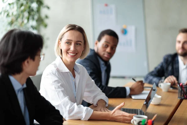 Exitosa mujer de negocios en reunión corporativa sonriendo a asiático hombre de negocios interior —  Fotos de Stock