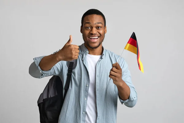 Glücklicher schwarzer Mann zeigt Daumen hoch und Deutschland-Fahne — Stockfoto