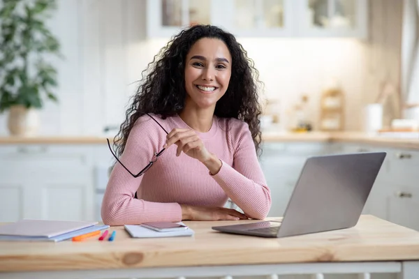 Zdalna przedsiębiorczość. Happy Millennial kobieta siedzi przy stole z laptopem w kuchni — Zdjęcie stockowe