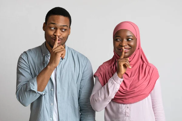 Мусульманські чорні пари роблять знак мовчання, тримати передніми пальцями губи — стокове фото