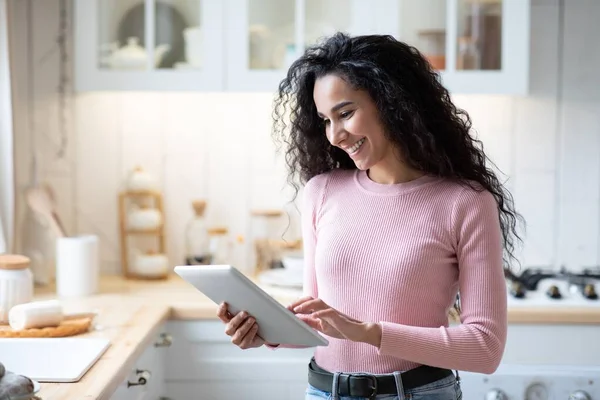 Online winkelen. Portret van gelukkige jonge vrouw met behulp van digitale tablet in de keuken — Stockfoto