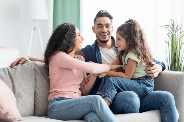 Familjefrihet. Glada Mellanösternföräldrar som har roligt med dottern hemma — Stockfoto