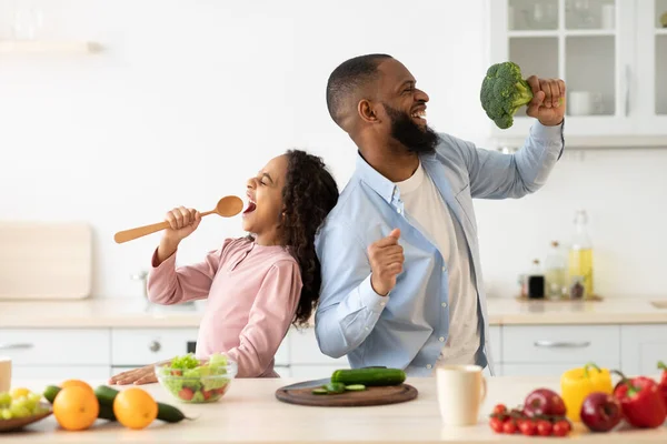 Père noir et fille chantant dans la cuisine en s'amusant — Photo