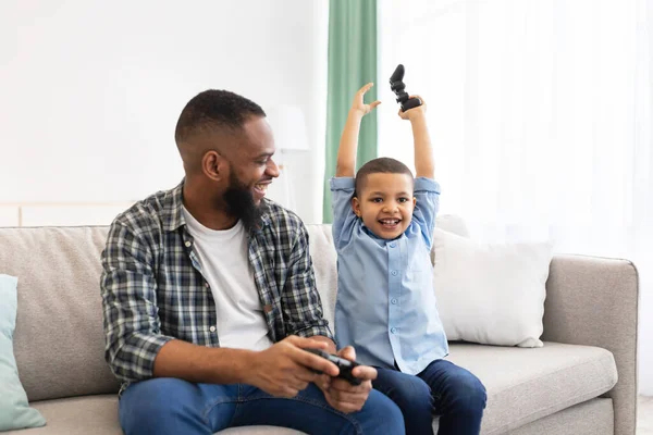 Emocionado chico africano y su papá ganando videojuego en casa — Foto de Stock