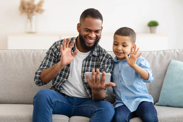 アフリカのお父さんと息子のビデオ通話自宅で電話 — ストック写真