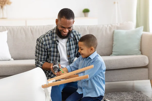 Hijo afroamericano y padre arreglando mesa en casa — Foto de Stock