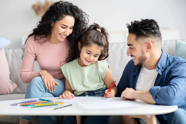 Amorosos padres árabes dibujando con su pequeña hija preescolar en casa — Foto de Stock