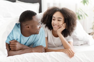 Genç aile rahatlar, romantik sohbet eder ve hafta sonu evde boş vakit geçirir.