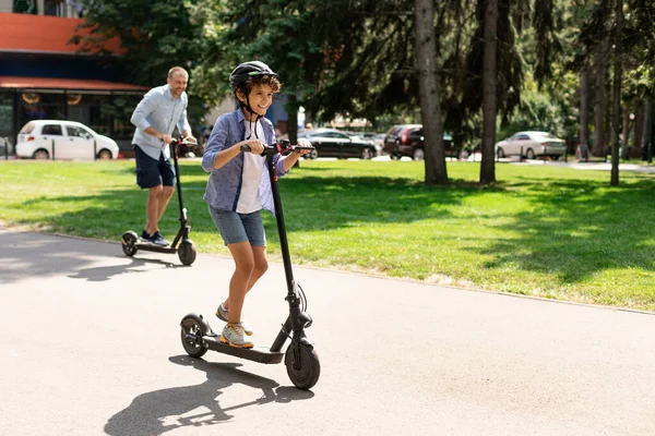 Mutlu çocuk ve babası e-scooter kullanıyor. — Stok fotoğraf