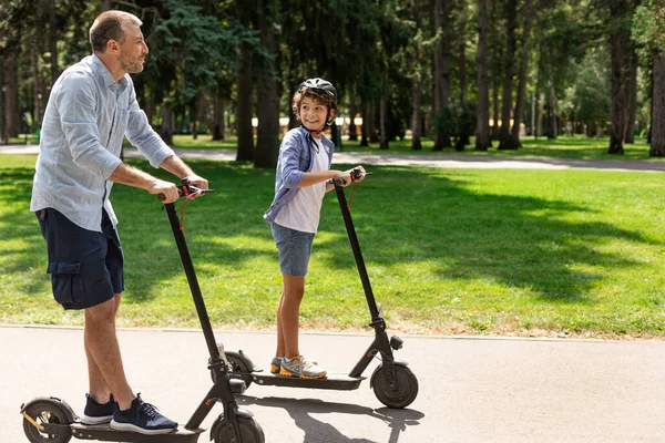 Šťastný chlap s tatínkem mají jízda na e-scooter — Stock fotografie