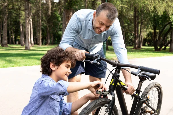 Closeup portrait of cheerful dad and son fixing bike — Stock Photo, Image