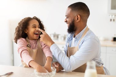 Zenci adam ve kızı unla oynuyorlar.