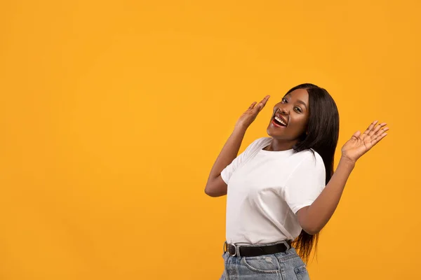 Aufgeregte schwarze Frau hebt die Hände in Richtung Kopierraum — Stockfoto