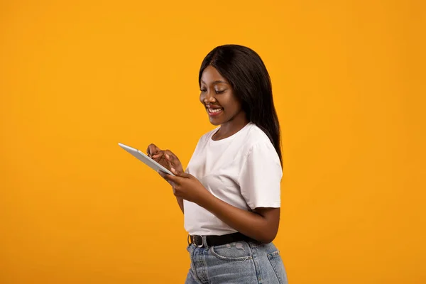 Mujer negra positiva con tableta digital moderna — Foto de Stock