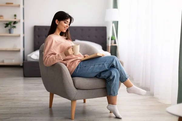 Kvinna som har vila hemma, dricka kaffe läsa bok — Stockfoto