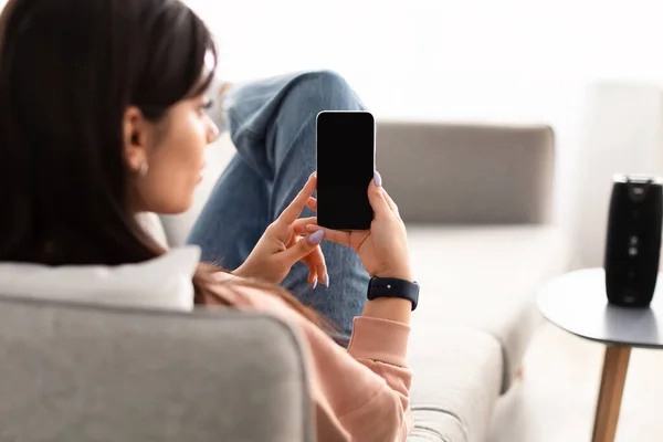 Vista posterior de la mujer usando el teléfono con la pantalla de maqueta vacía —  Fotos de Stock