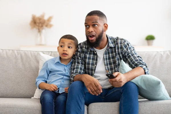 Confuso papà e figlio guardando la TV, commutazione di contenuti discutibili Indoor — Foto Stock