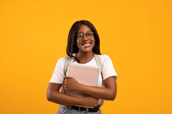 Leende svart dam student med ryggsäck och anteckningsböcker — Stockfoto