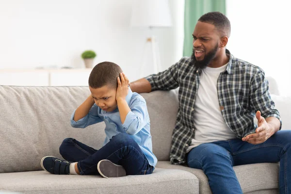 Angry Black Dad Shouting At Unhappy Son Sitting At Home — Stock Photo, Image