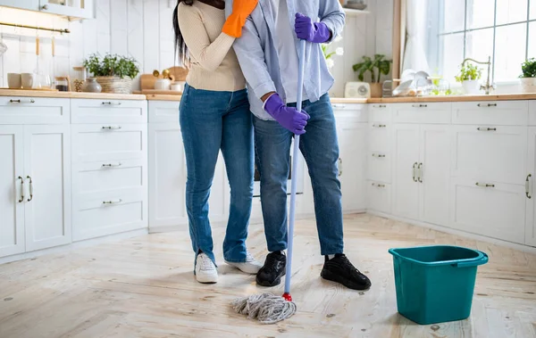 Gewassen uitzicht op Afro-Amerikaans paar met dweil doet huishoudelijke opruimen in de keuken, panorama — Stockfoto