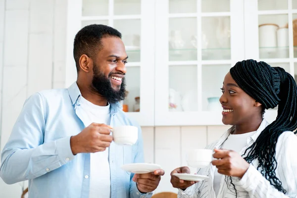 朝のチャット。キッチンでコーヒーを飲む幸せな黒の若いカップル — ストック写真