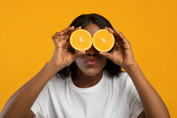 Drôle afro-américaine dame couvrant les yeux avec des moitiés orange — Photo