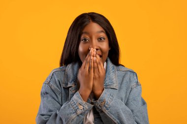 Ağzını kapatan kot ceketli harika siyahi kadın.