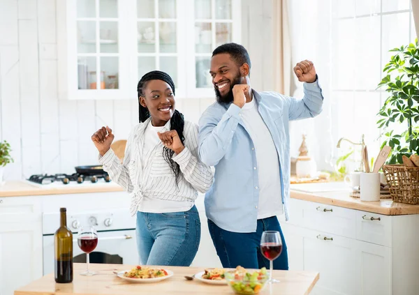 Cita en casa. alegre negro pareja bailando en cocina después romántico almuerzo —  Fotos de Stock