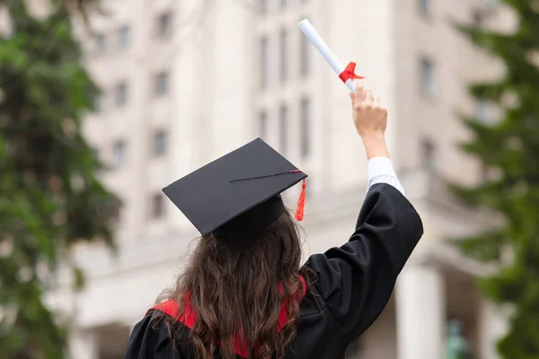 Baksidan av brunett dam i examen kostym — Stockfoto