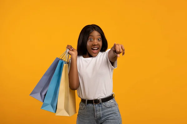 脇を指してショッピングバッグと素晴らしい黒の女性 — ストック写真