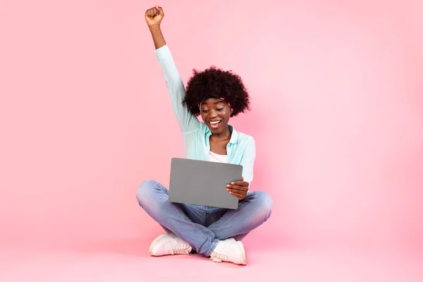 喜びの黒の女性とともにノートパソコンの揺れ拳でピンクの背景 — ストック写真