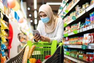 Süpermarkette Market Alışverişi yapan İslami Kadın Akıllı Telefon Kullanıyor