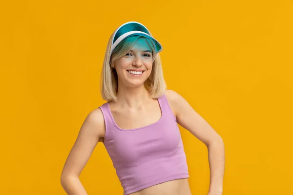 Mujer feliz en colorido sombrero de verano posando sobre fondo amarillo estudio, sonriendo y mirando a la cámara —  Fotos de Stock